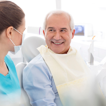 dentist talking to smiling senior patient at dental clinic