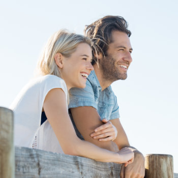 young couple smiling and embracing looking into the distance