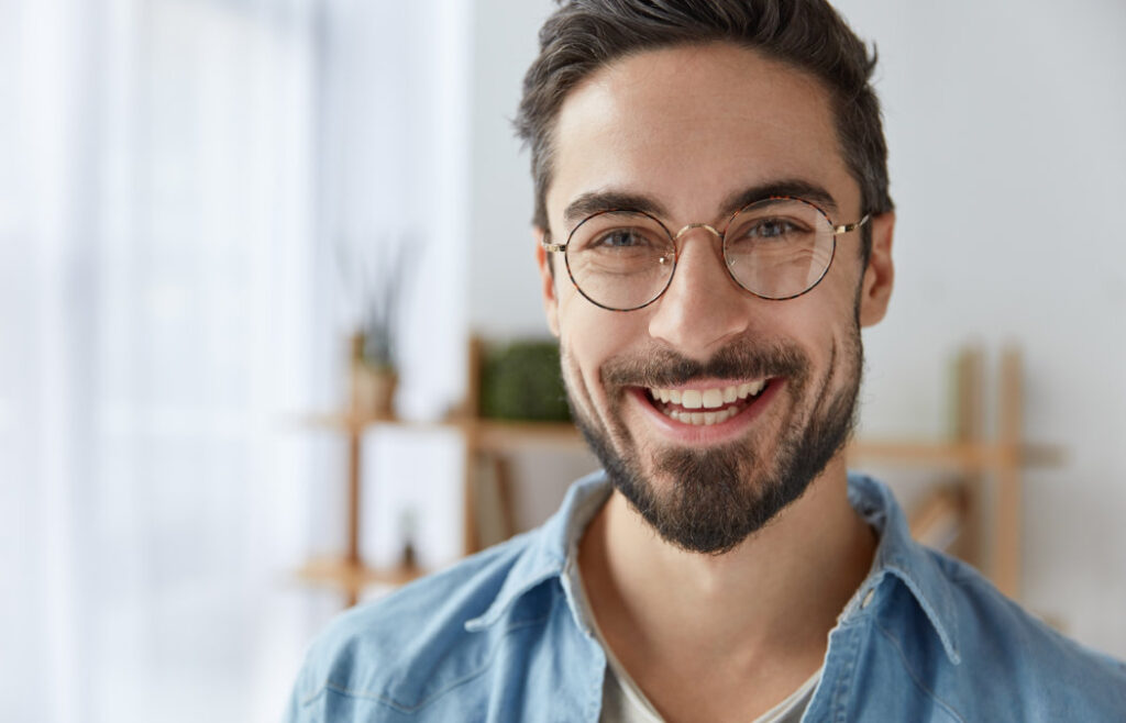 Have Your Best Summer Smile Ever with Porcelain Veneers 3 Smiling man with glasses and beard