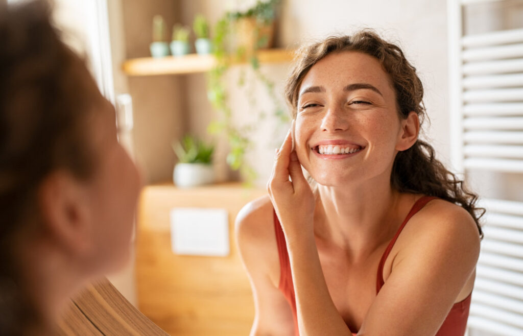 women in front of mirror Best Whitening for Sensitive Teeth​