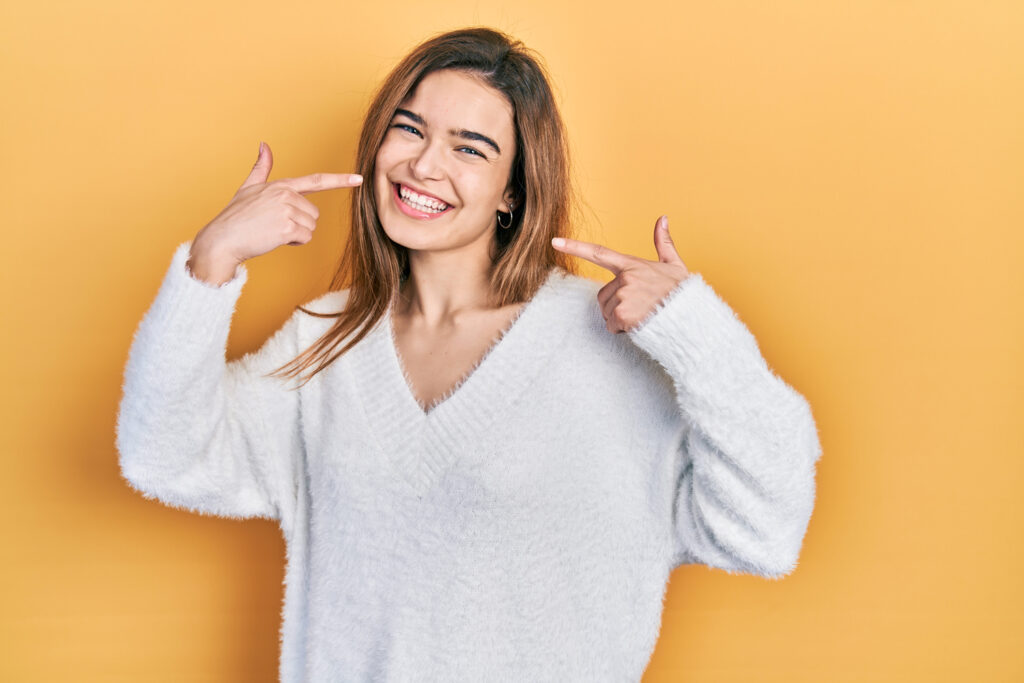 Woman pointing to her bright smile