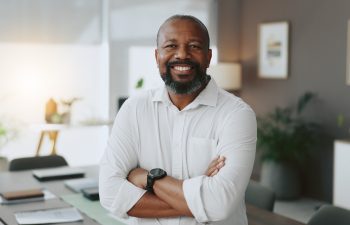 Mature, portrait or black man with arms crossed in office as confident project manager for development. Opportunity, smile or proud entrepreneur in startup company with mission or business commitment