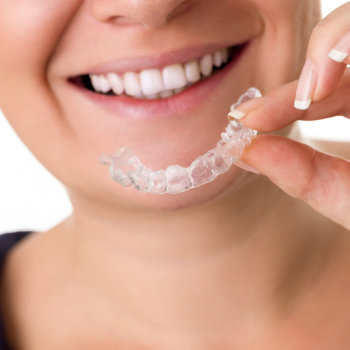 Woman holding Invisalign with smile