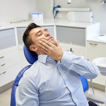 Man with a toothache in a dental chair
