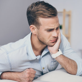 Man holding his cheek with tooth pain