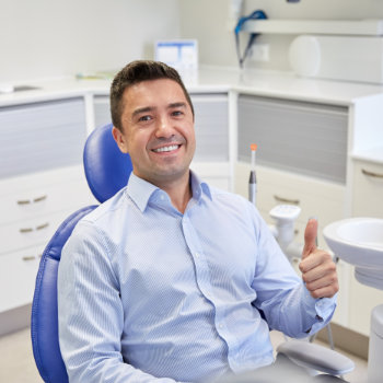 Satisfied man thumbs up in chair Duluth Dental Studio visit