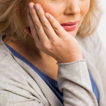 Senior woman holding her cheek in pain