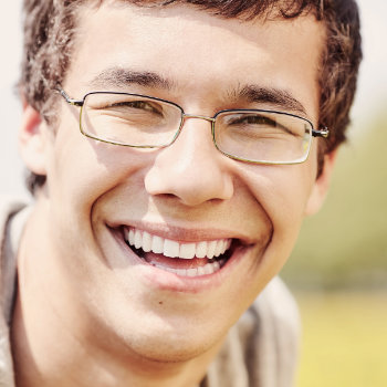 Young man with glasses smiling Duluth Dental Studio patient