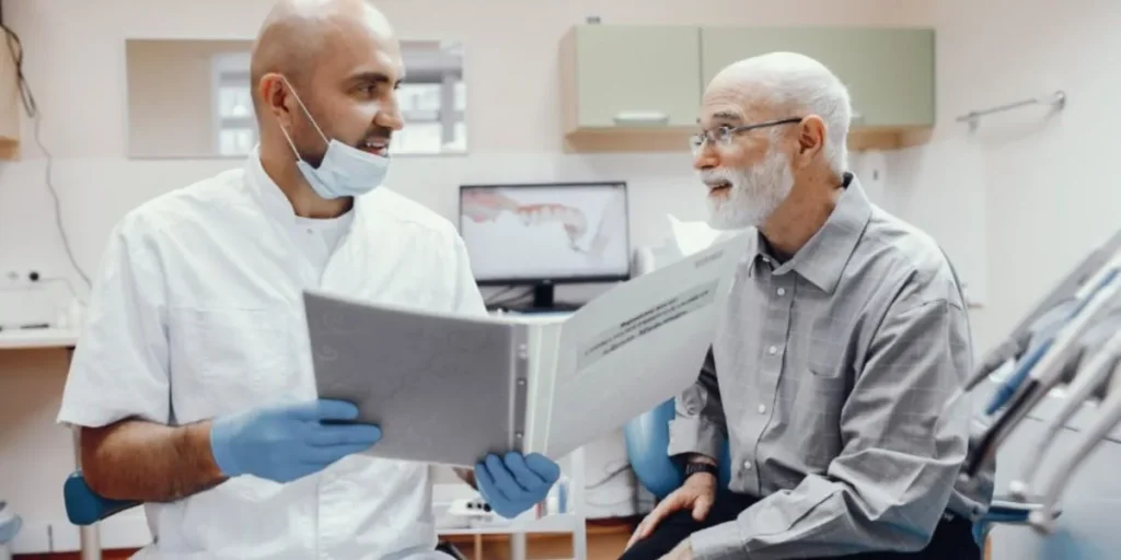 Dentist explaining affordable dental care options to senior man