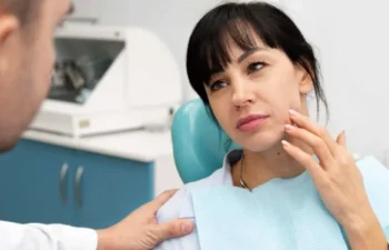 Woman speaking with emergency dentist about tooth pain