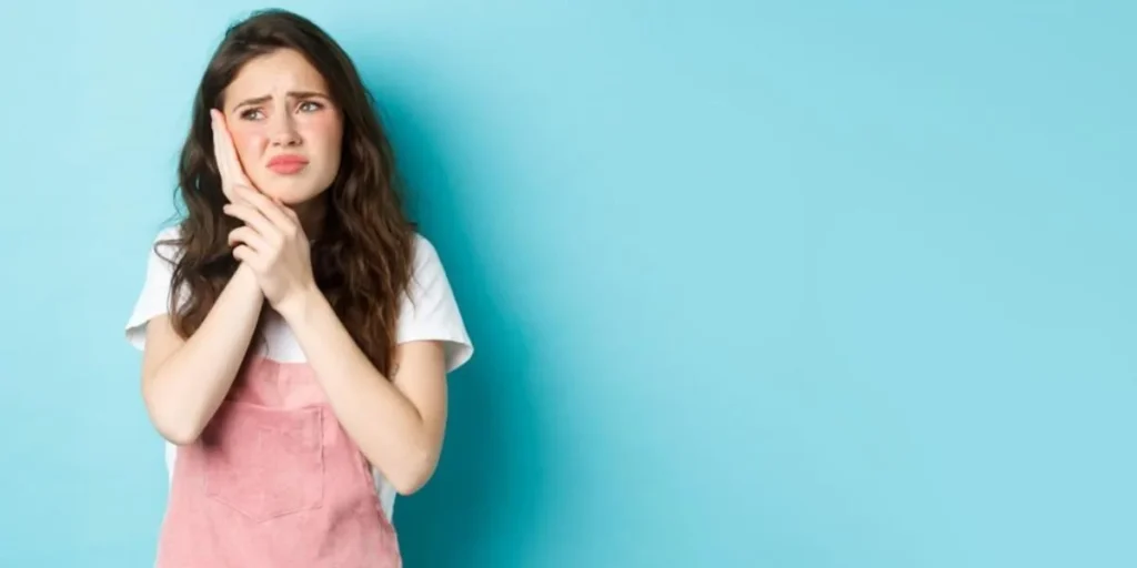 Young woman suffering from severe tooth pain in Duluth